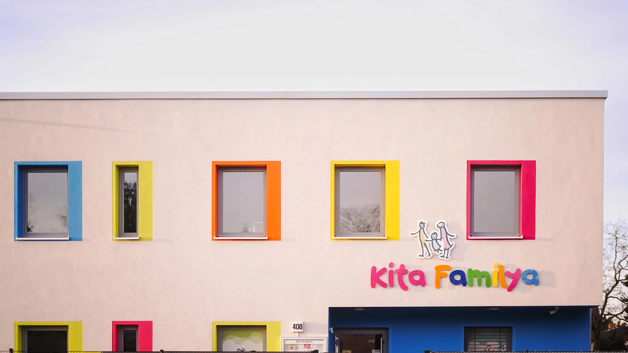 Großer Innenhof der Kita Familya Gropiusstadt mit Spielgeräten an einem sonnigen Tag